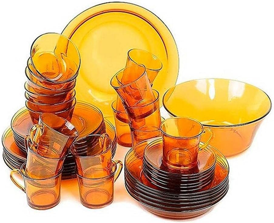 Set of amber-colored glassware including cups, bowls, and plates on a white background
